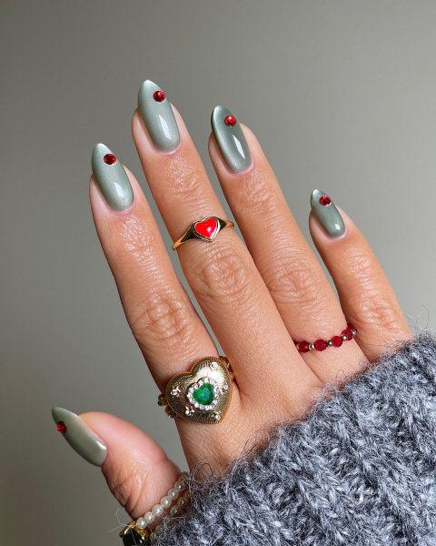 Close up of velvet green nails with red studs